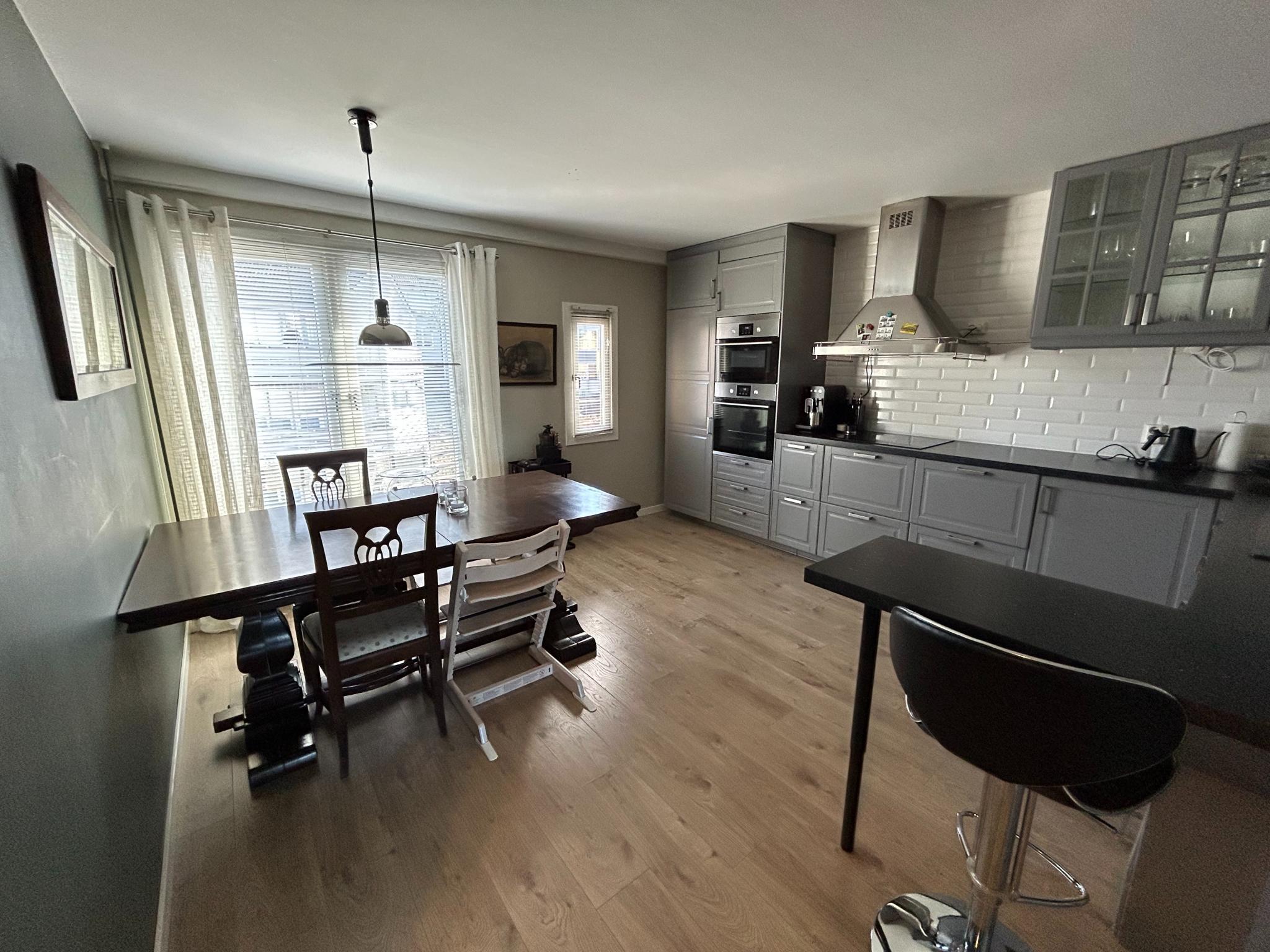 Stort lyst og oversiktlig kjøkken med integrerte hvitevarer.